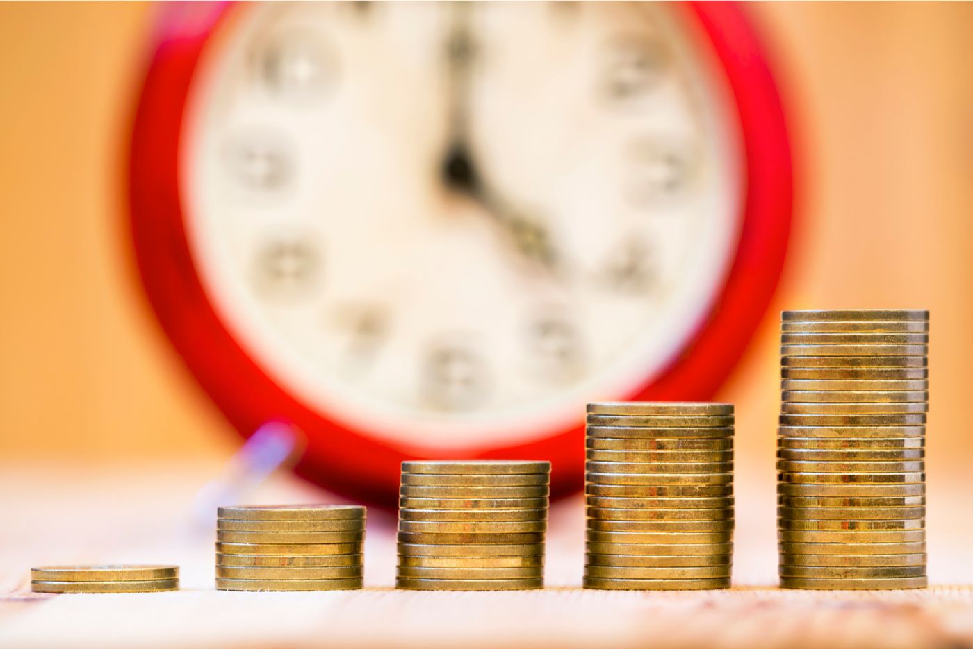 Compounding interest respresented with coins and clock Compounding interest respresented with coins and clock