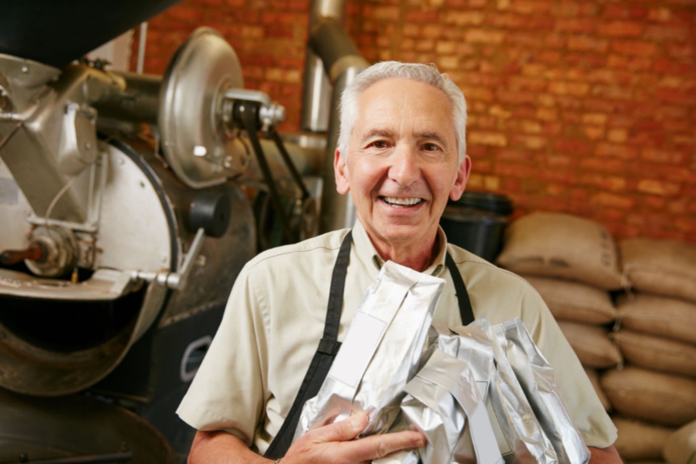 Smiling man holding coffee bags