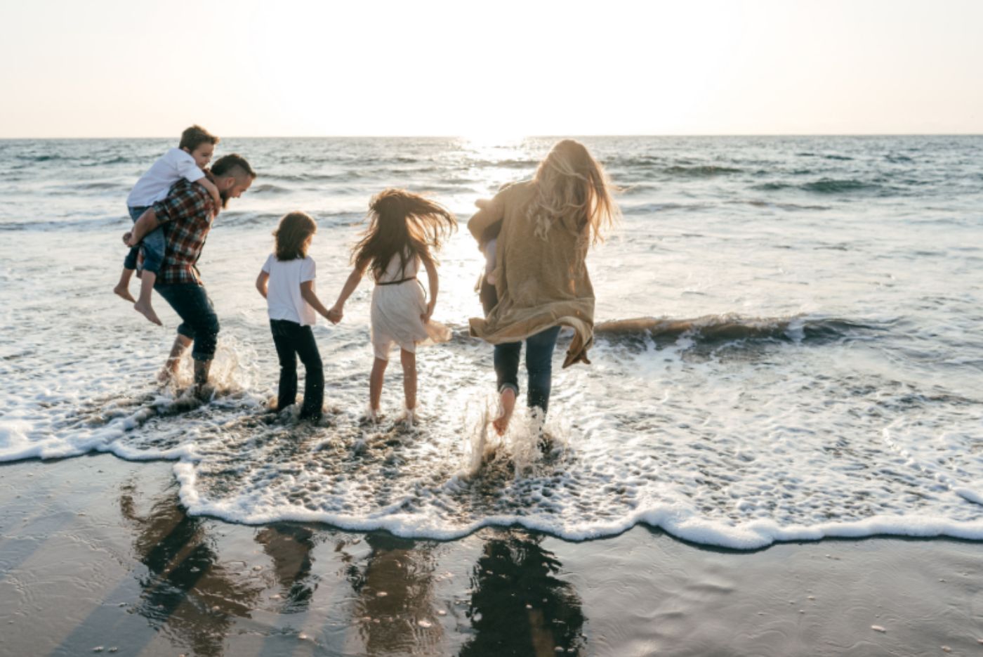 Family playing together in the waves on the beach